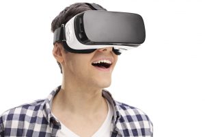 Young man experiencing virtual reality through a VR headset isolated on white background